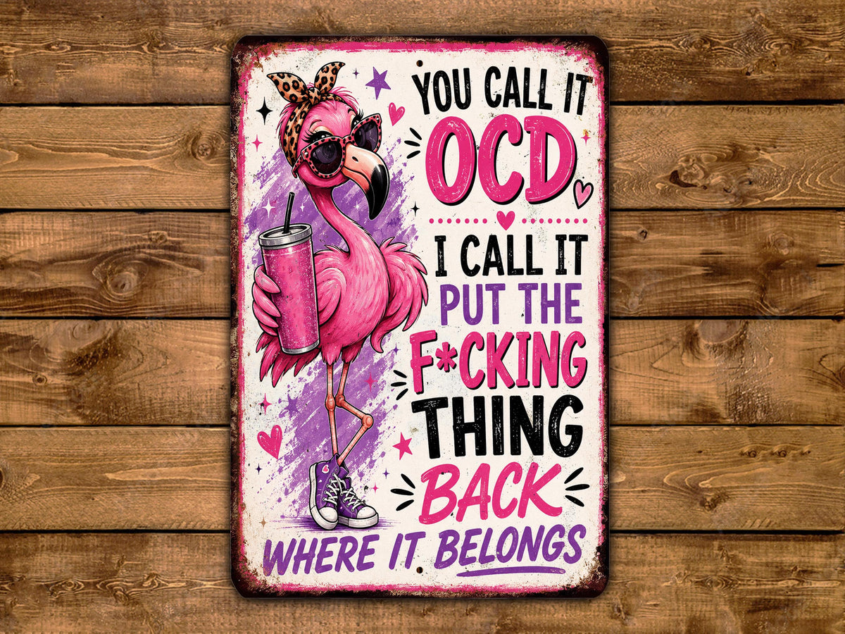 a pink flamingo holding a drink and wearing sunglasses, with text surrounding it that reads "You call it OCD, I call it put the F*cking thing back where it belongs".
