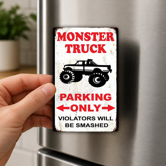 A person's hand is holding a sign that says "MONSTER TRUCK PARKING ONLY VIOLATORS WILL BE SMASHED".
