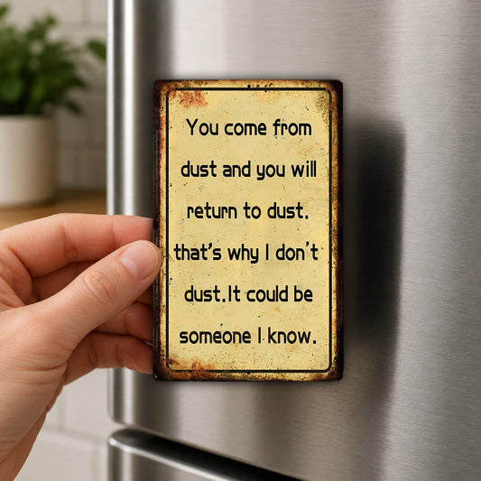 A hand holding a metal magnet with a quote on it, which is attached to a refrigerator.