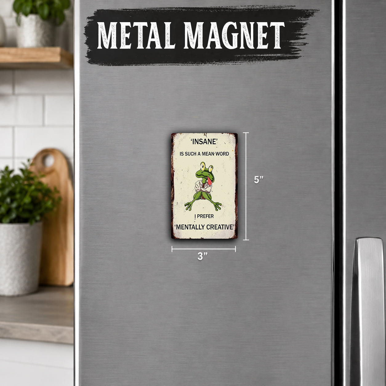 a small metal refrigerator magnet with a frog on it. The magnet is described as a "metal magnet" and "insane" with a humorous message about creativity. The magnet is approximately 5 inches in size.