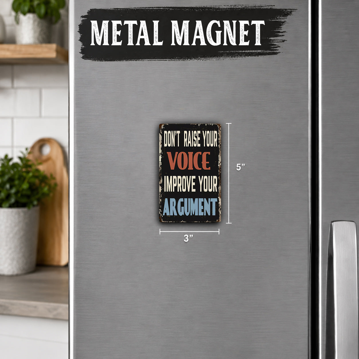 a small, vintage-style metal magnet with the text "Don't raise your voice, improve your argument" on it. The magnet is placed on a refrigerator, which is part of a kitchen setting.
