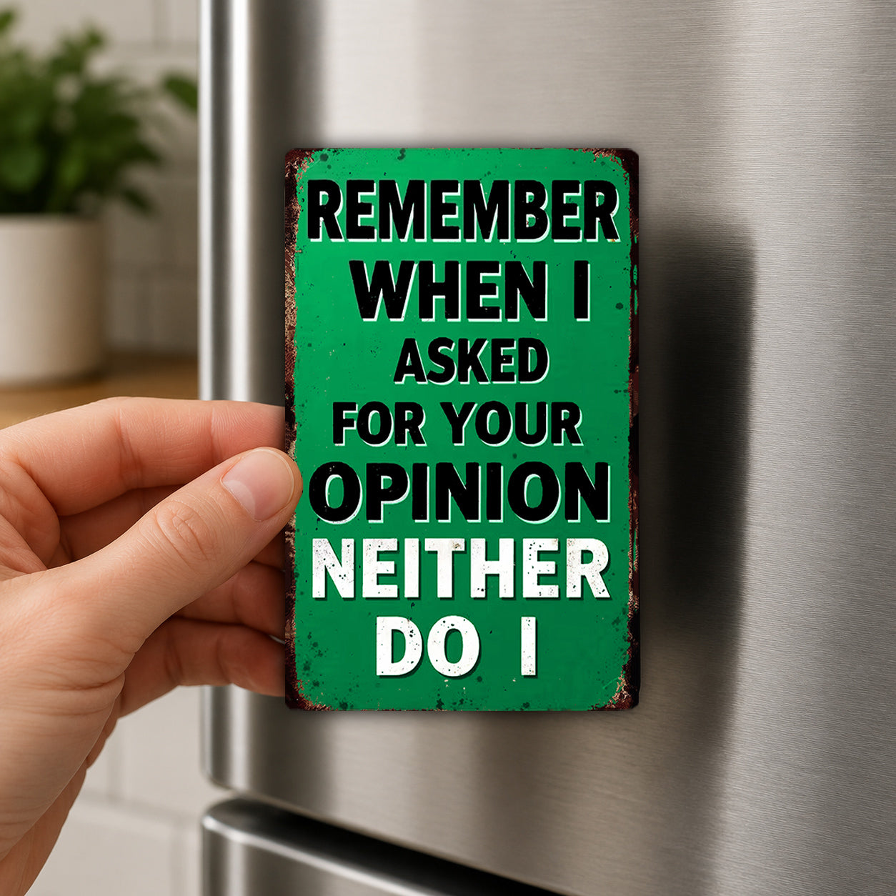 A person's hand holding a green sign with the text "Remember When I Asked For Your Opinion Neither Do I" on it.