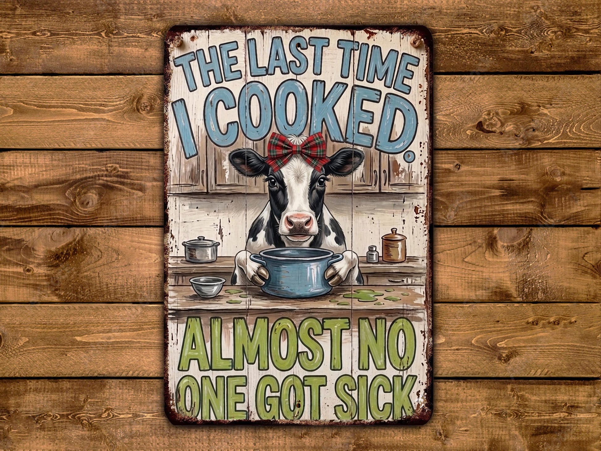 a cow sitting at a kitchen counter, holding a pot, and surrounded by various kitchen items. The text above the cow reads "THE LAST TIME I COOKED ALMOST NO ONE GOT SICK".