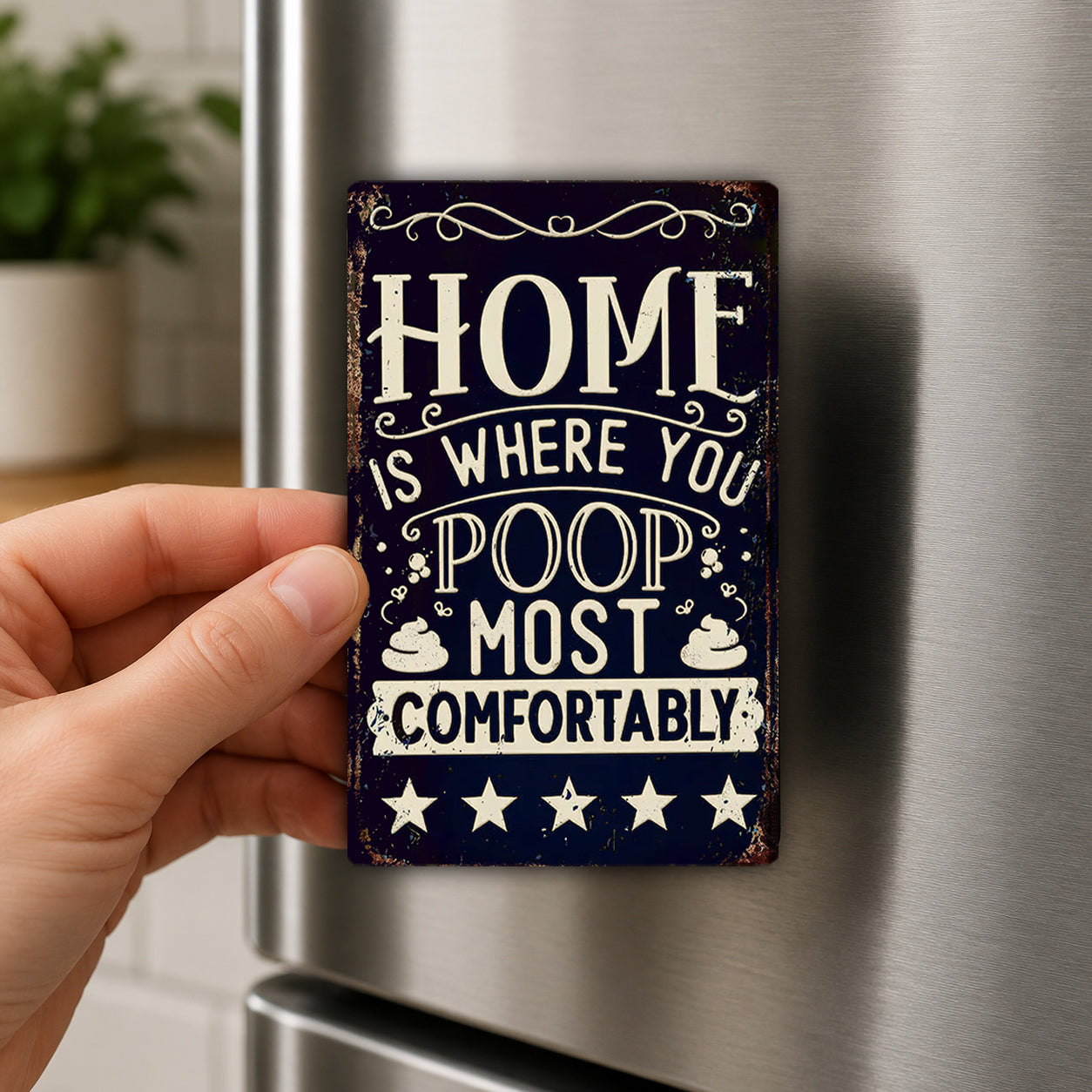 A hand is holding a sign that says "HOME IS WHERE YOU POOP MOST COMFORTABLY" in a vintage style.