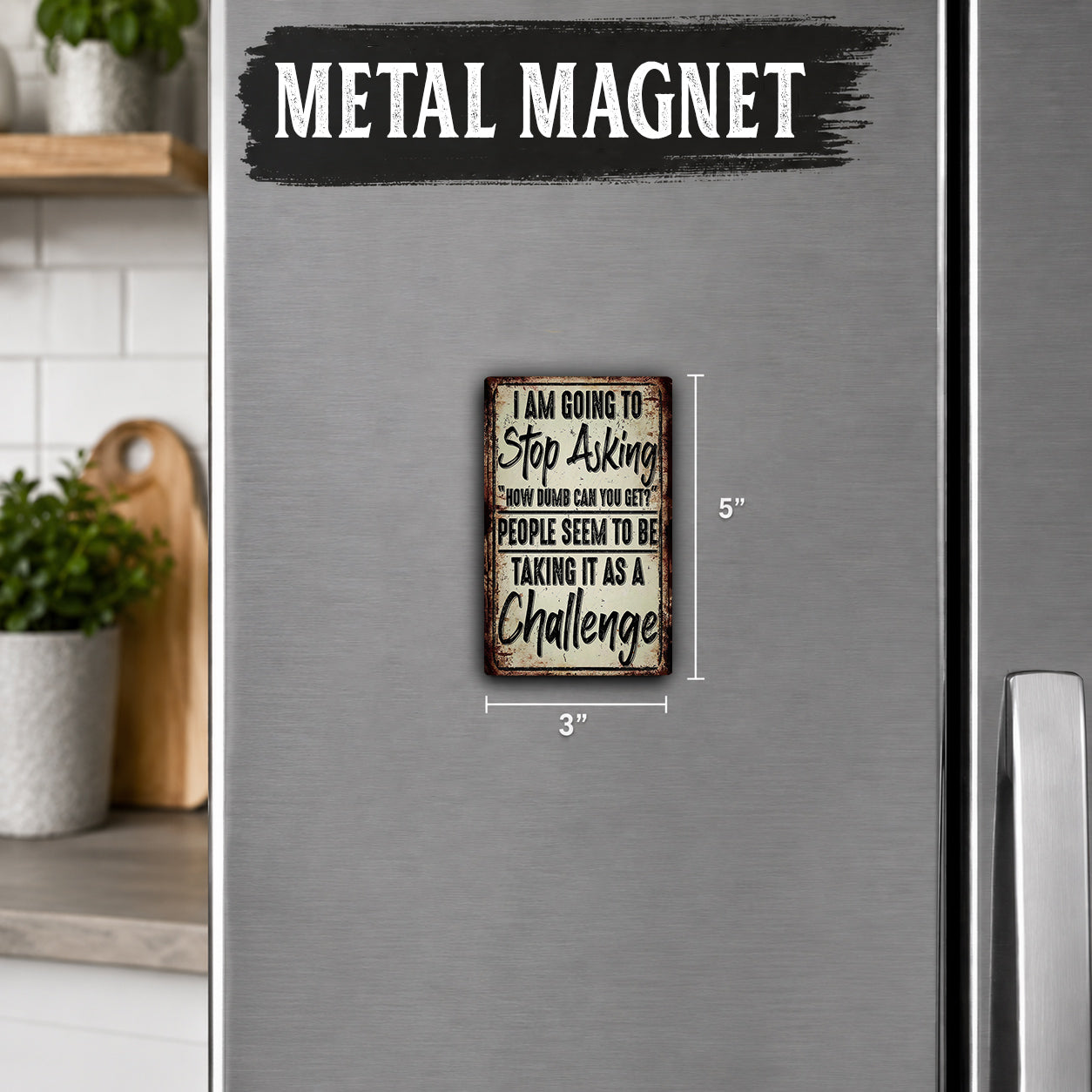 a small metal magnet with a humorous message on it, placed on a refrigerator.