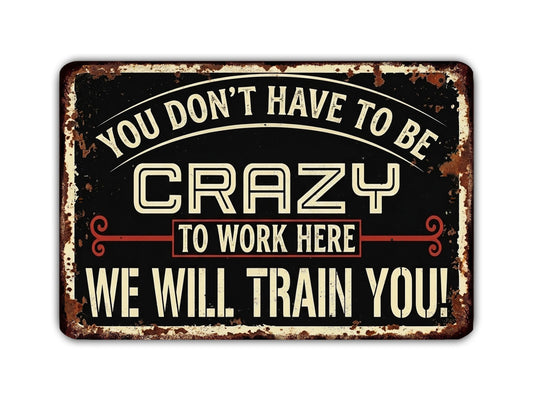a sign with the text "You don't have to be crazy to work here. We will train you!" The sign is in a vintage style with a distressed appearance.