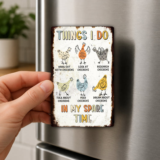 a person holding a small, colorful metal sign with illustrations of chickens and text that says "THINGS I DO IN MY SPARE TIME".