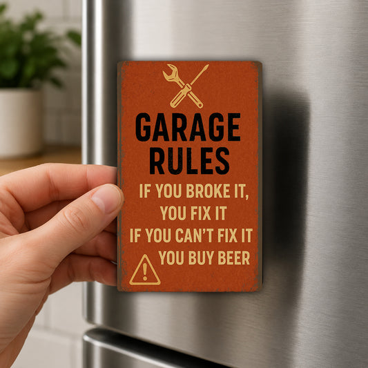 a person's hand holding a small orange sign with black text and a warning symbol, which appears to be a humorous reminder about garage rules.