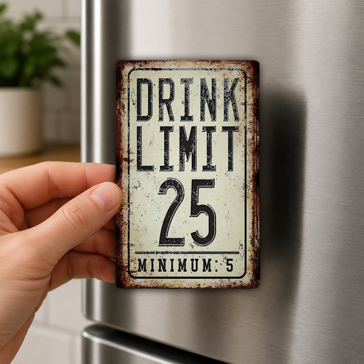 A person's hand is holding a metal sign with the text "DRINK LIMIT 25 MINUM: 5" on it.