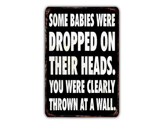 a sign with the text "Some babies were dropped on their heads. You were clearly thrown at a wall."