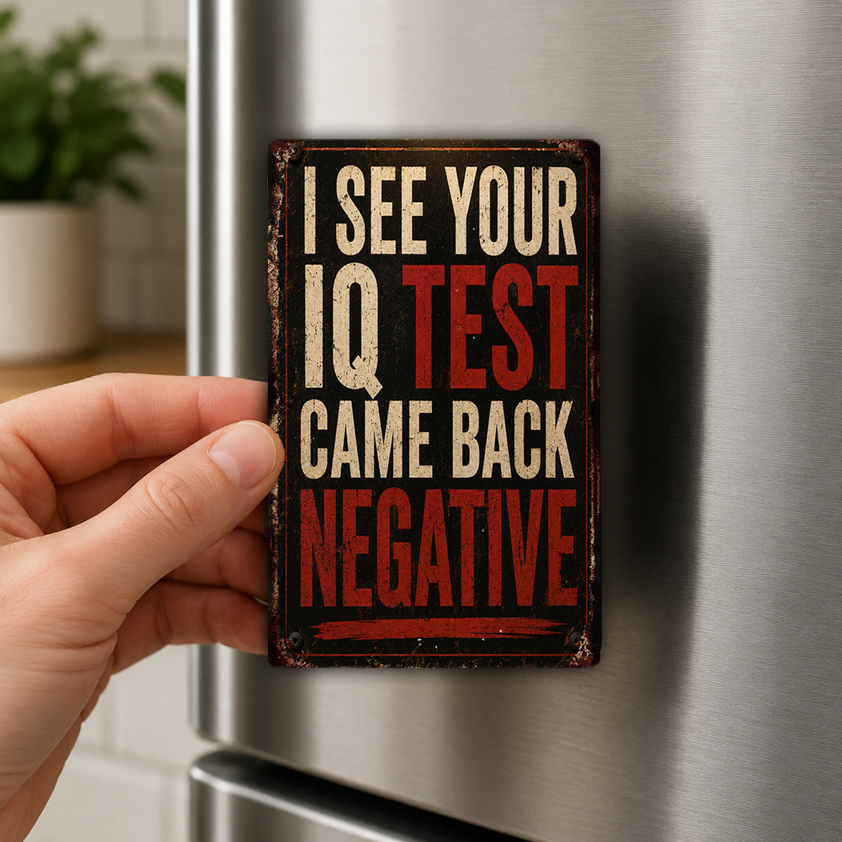 A person's hand is holding a metal sign with the text "I SEE YOUR IQ TEST CAME BACK NEGATIVE" on it.
