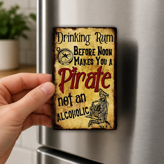 A person's hand is holding a small, vintage-style sign that reads "Drinking Rum Before Noon Makes You a Pirate Not an Alcoholic".