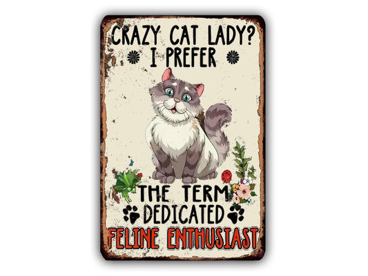 The image is a humorous sign featuring a cartoon cat and the text "Crazy Cat Lady? I Prefer The Term Dedicated Feline Enthusiast".