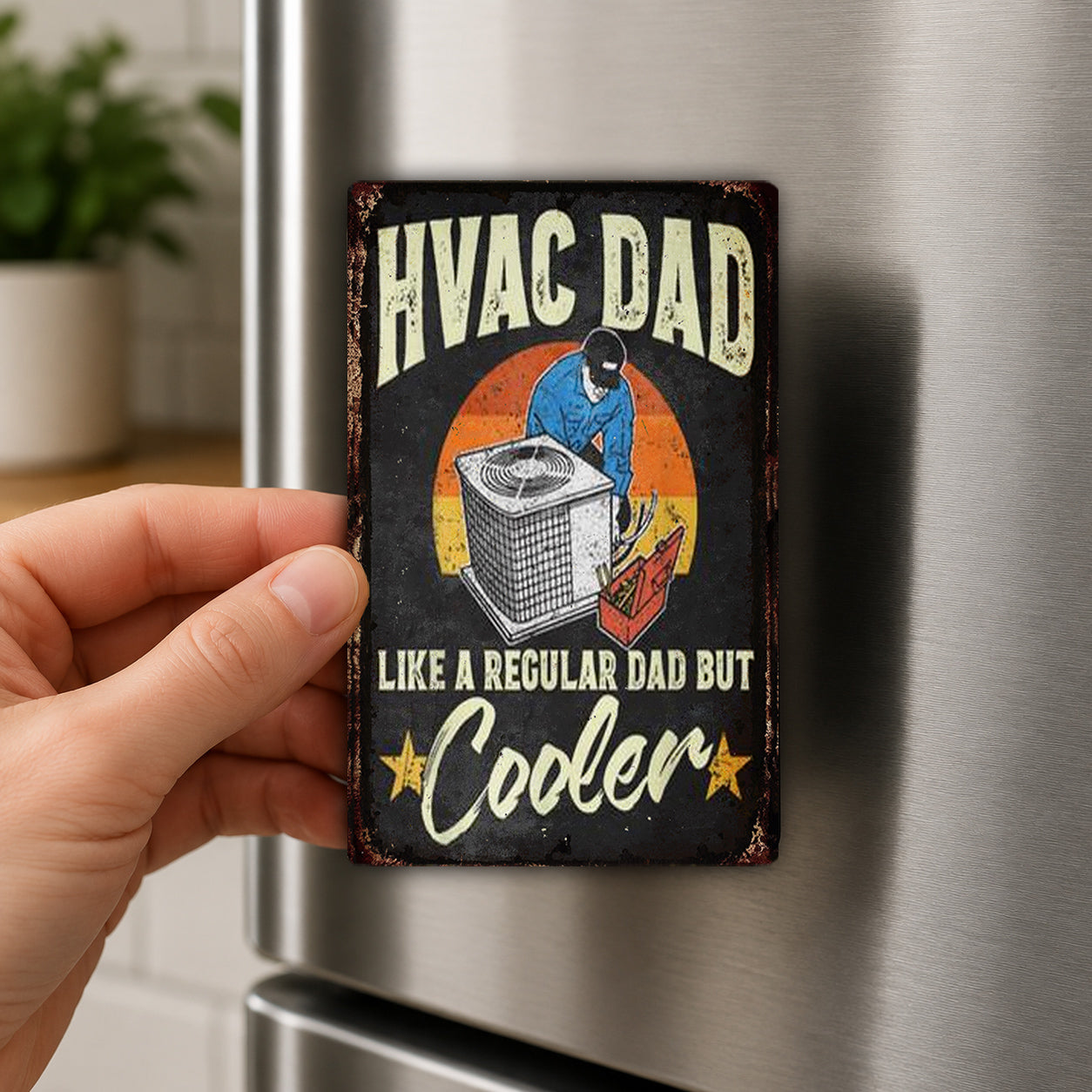 a person holding a vintage-style magnet with a humorous message about HVAC (Heating, Ventilation, and Air Conditioning) technicians.