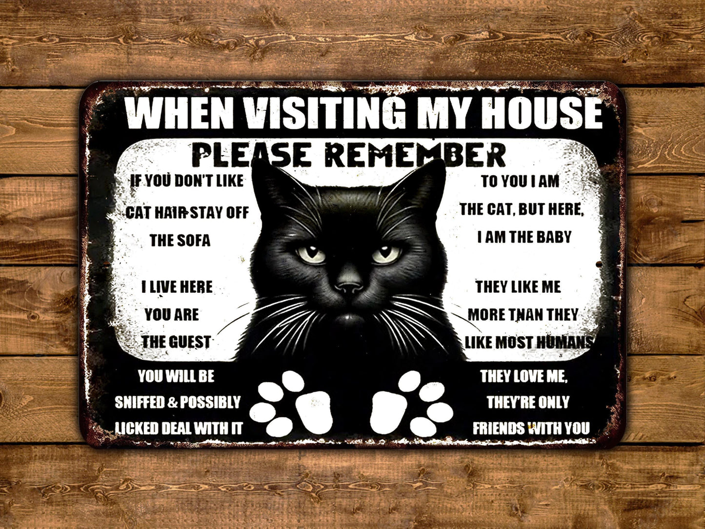 a sign with a black cat saying when visiting my house please remember