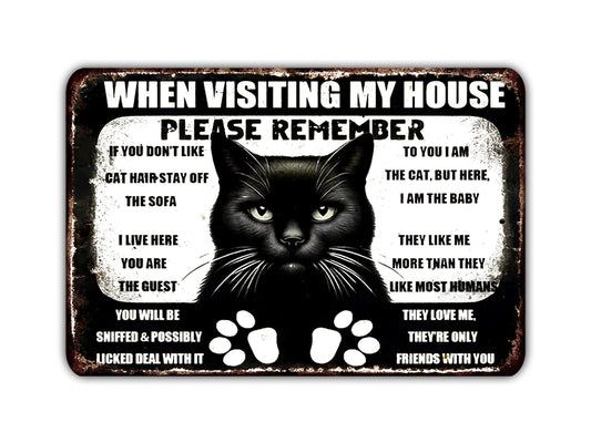 a metal sign with a black cat saying when visiting my house please remember