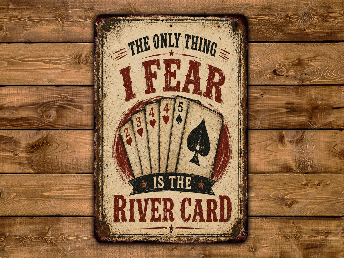 A vintage-style sign with the text "THE ONLY THING I FEAR IS THE RIVER CARD" and a graphic of playing cards.