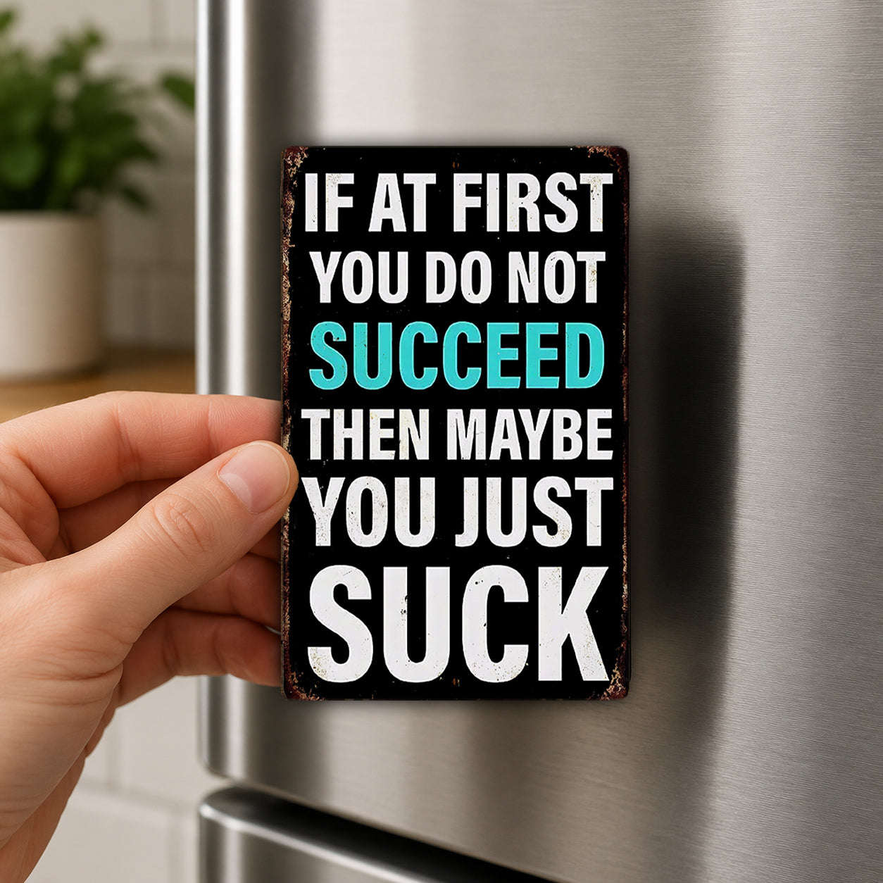 a person's hand holding a sign with the text "IF AT FIRST YOU DO NOT SUCCEED THEN MAYBE YOU JUST SUCK" on it.