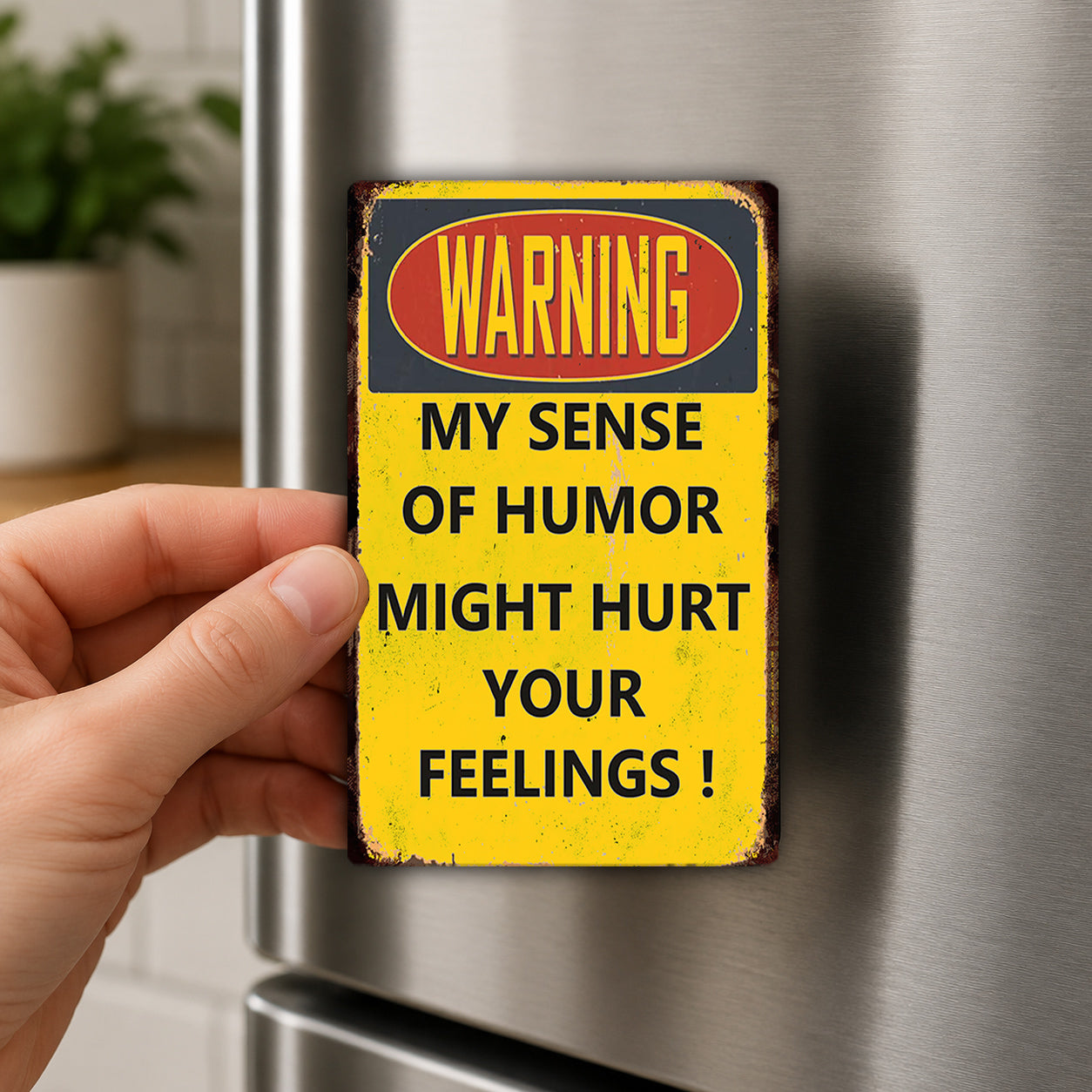A person's hand holding a yellow sign with a warning message.