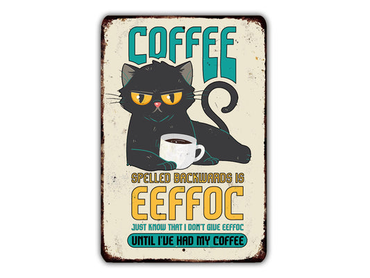 The image is a humorous sign featuring a black cat with yellow eyes and a cup of coffee, accompanied by the text "COFFEE SPELLED BACKWARDS IS EEFOC" and a humorous caption " Until I've had my coffee".