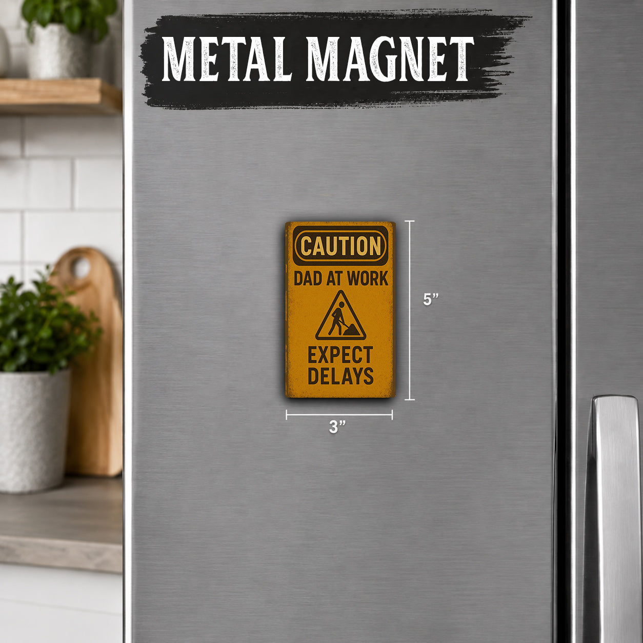 a metal refrigerator with a warning sign attached to it. The sign reads "CAUTION DAD AT WORK EXPECT DELAYS" and is approximately 5 inches tall.