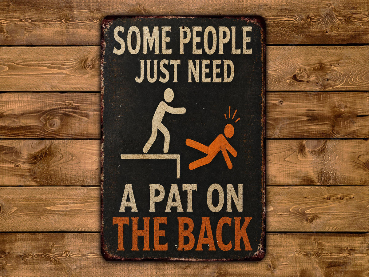 a sign with the text "Some people just need a pat on the back" and an illustration of a person being pushed or pushed by another person.