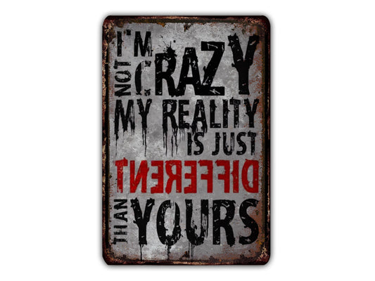 a sign with the text "I'M NOT CRAZY, MY REALITY IS JUST DIFFERENT FROM YOURS" in a distressed, distressed font.