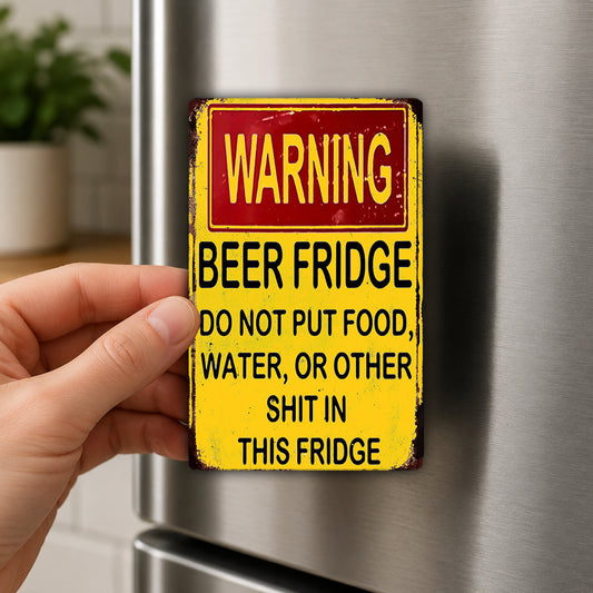 A person's hand is holding a yellow and red warning sign attached to a refrigerator.