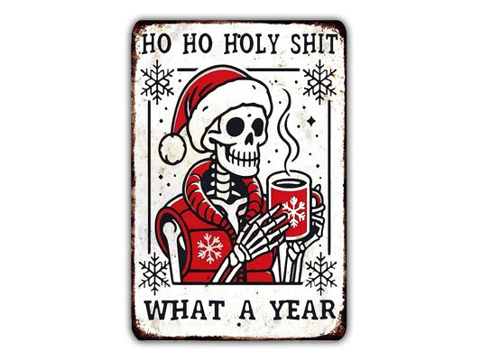 A metal sign with a skeleton wearing a Santa hat and holding a mug, surrounded by snowflakes and the text "HO HO HOLY SHIT WHAT A YEAR".