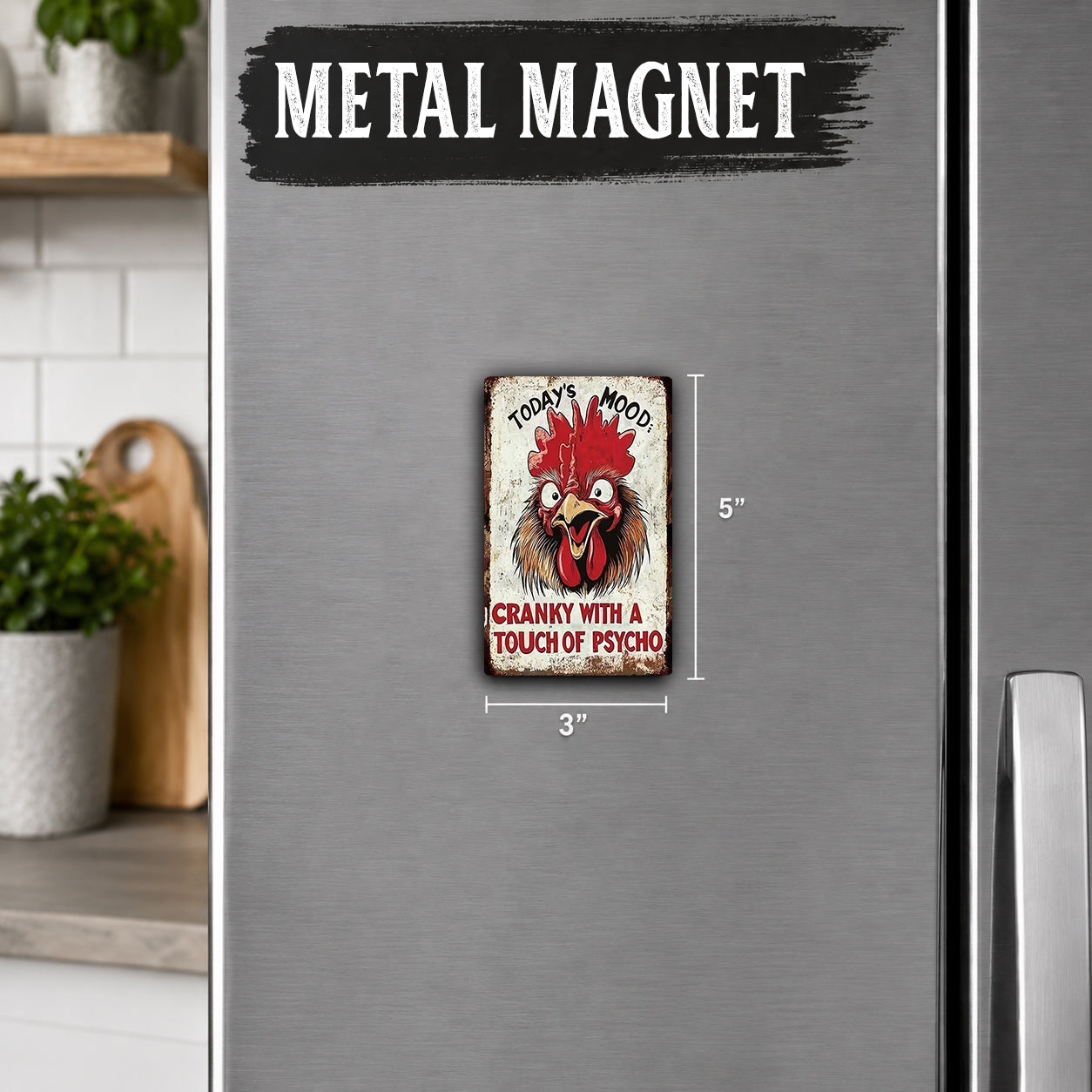 a small, vintage-style metal magnet with a rooster design on it, placed on a refrigerator.
