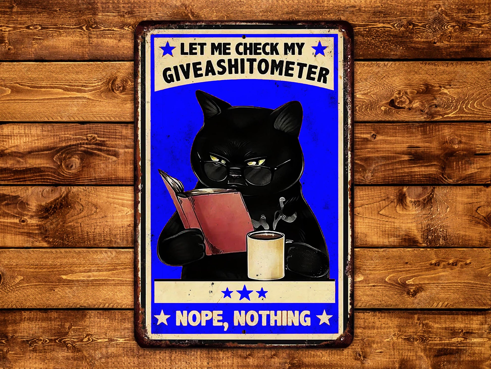 a sign with a black cat holding a book and a cup of coffee, with the text "LET ME CHECK MY GIVEASHITOMETER" and "NOPE, NOTHING" displayed on it.