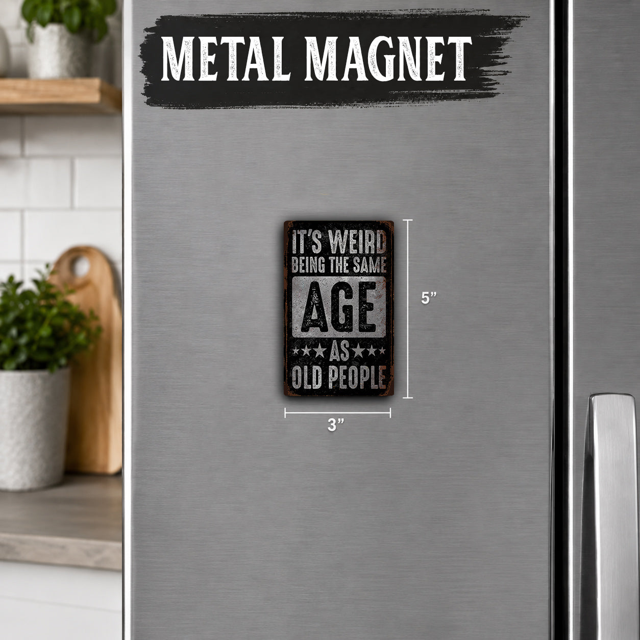 a small, metal-colored refrigerator magnet with the text "IT'S WEIRD BEING THE SAME AGE AS OLD PEOPLE" printed on it.