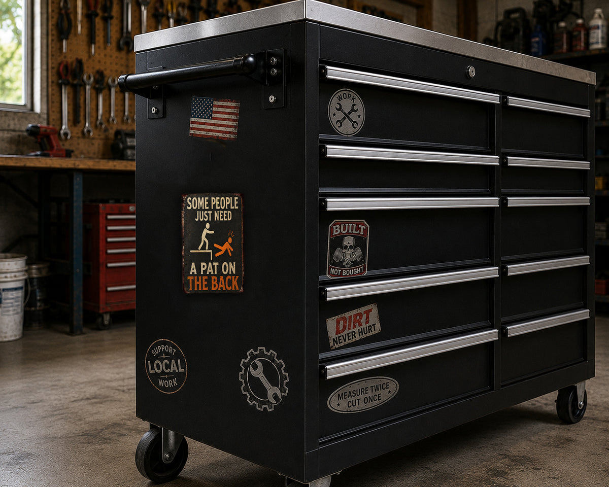 A black tool chest with various stickers and labels on it, placed in a workshop setting.
