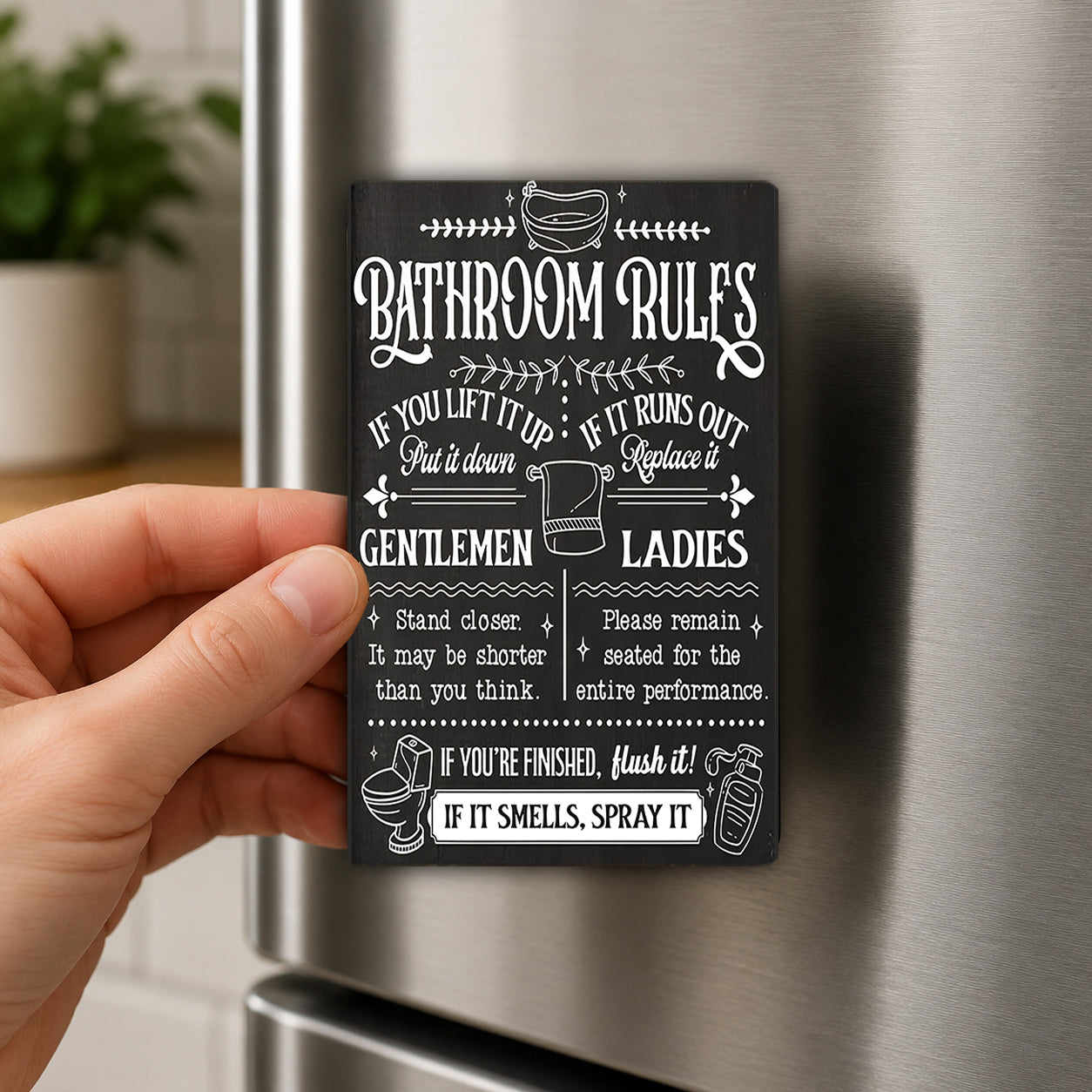 A hand holding a black and white sign with instructions for bathroom rules.