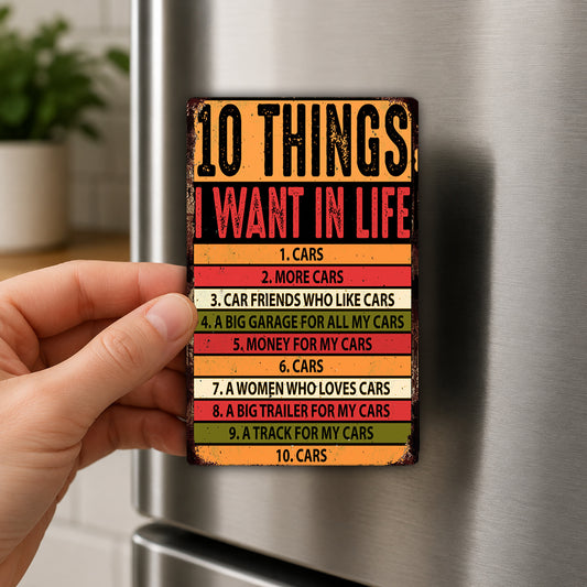 A person's hand holding a colorful, vintage-style magnet with the text "10 THINGS I WANT IN LIFE" on it.