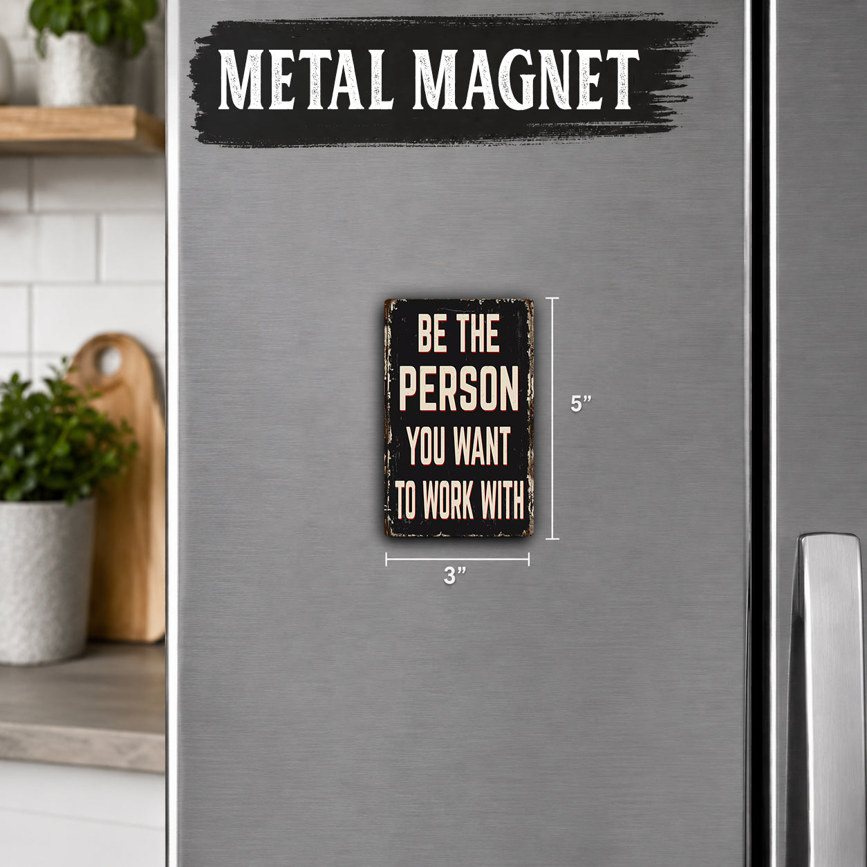 a small metal magnet with the text "Be the person you want to work with" on it.