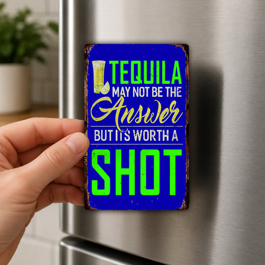 A hand holding a metal sign with the text "Tequila may not be the answer but its worth a shot" on it.