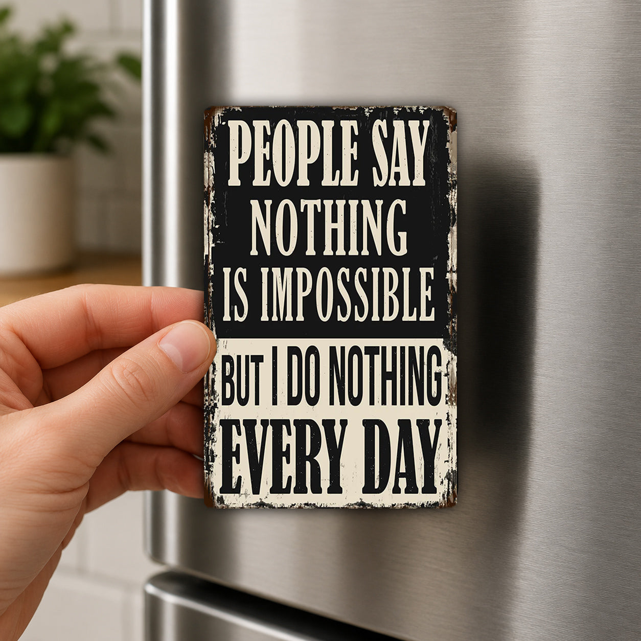 A person's hand holding a sign with the text "PEOPLE SAY NOTHING IS IMPOSSIBLE BUT I DO NOTHING EVERY DAY" on it.