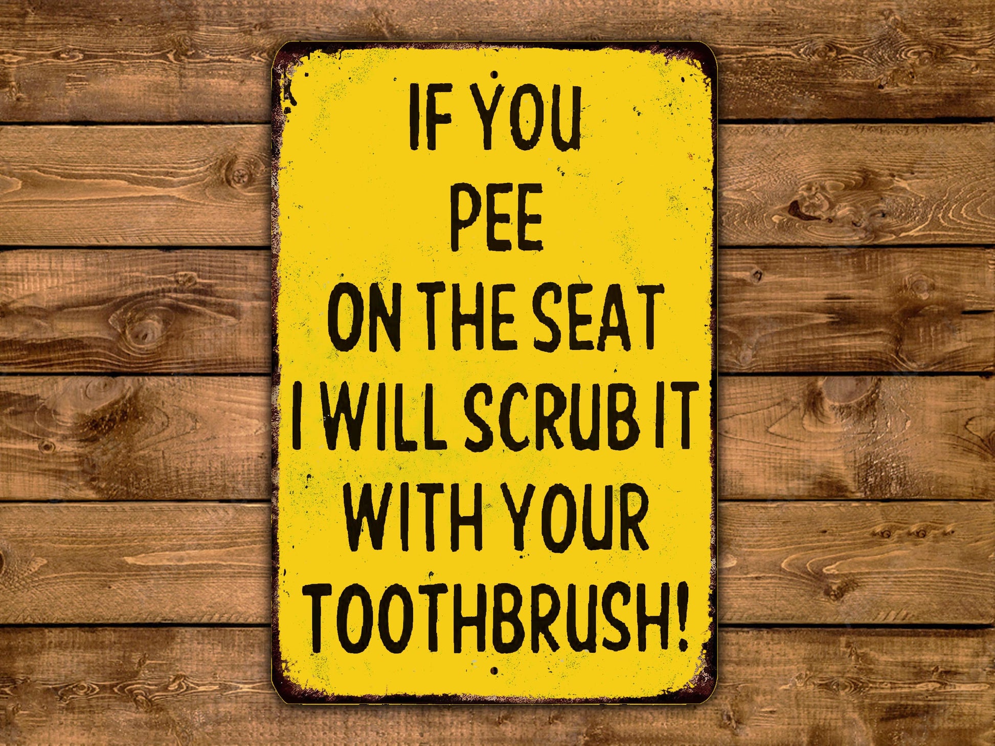 a yellow sign with black text that reads "IF YOU PEE ON THE SEAT I WILL SCRUB IT WITH YOUR TOOTHBRUSH!"