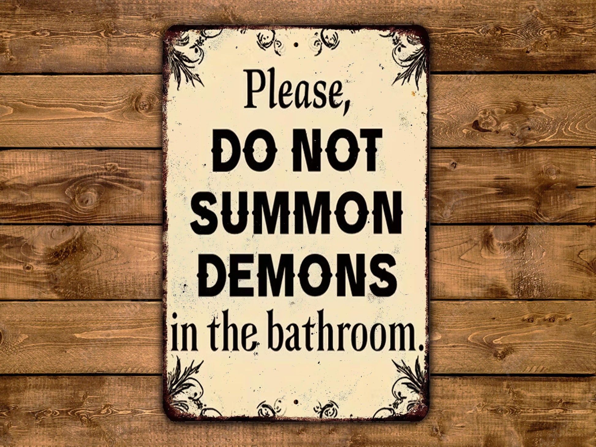 A metal sign with the text "Please, DO NOT SUMMON DEMONS in the bathroom."