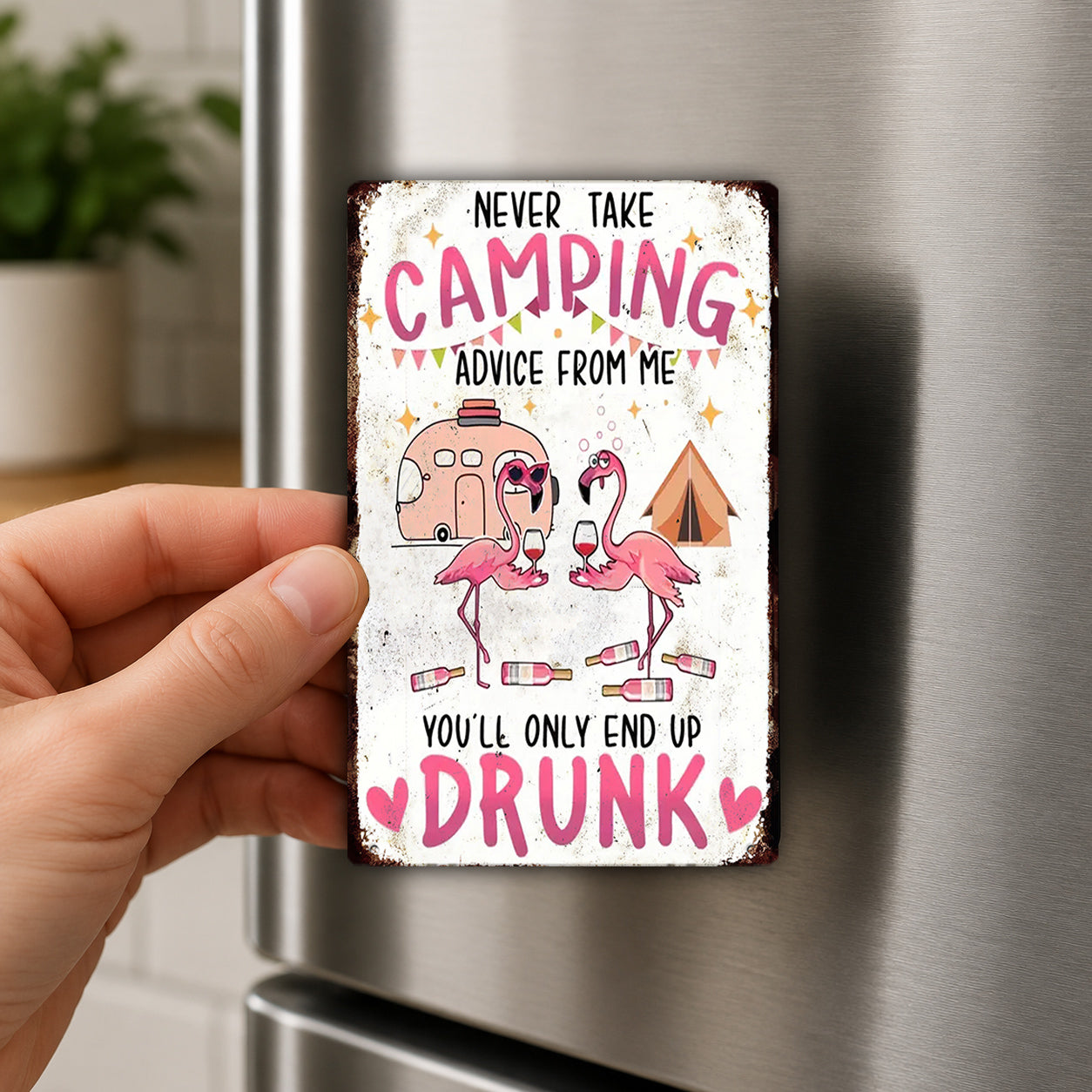 a person holding a metal sign with a humorous message about camping and drinking.