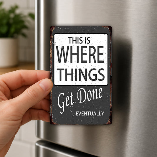 A hand is holding a black and white sign with the text "THIS IS WHERE THINGS GET DONE" and "EVENTUALLY" on it.