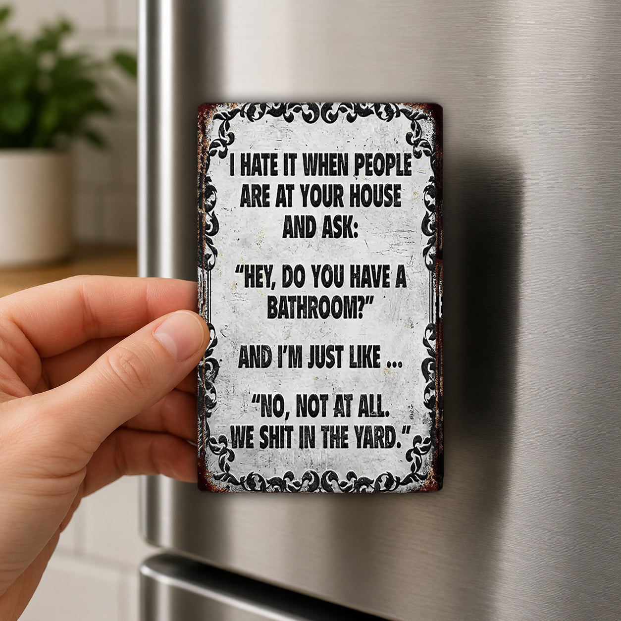 A person's hand holding a metal sign with a humorous text on it.