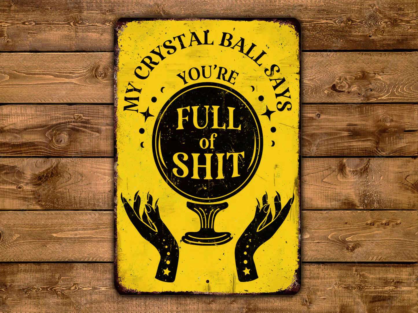 a yellow sign with a black and white design, displaying the text "MY CRYSTAL BALL SAYS FULL OF SHIT" along with a crystal ball illustration.