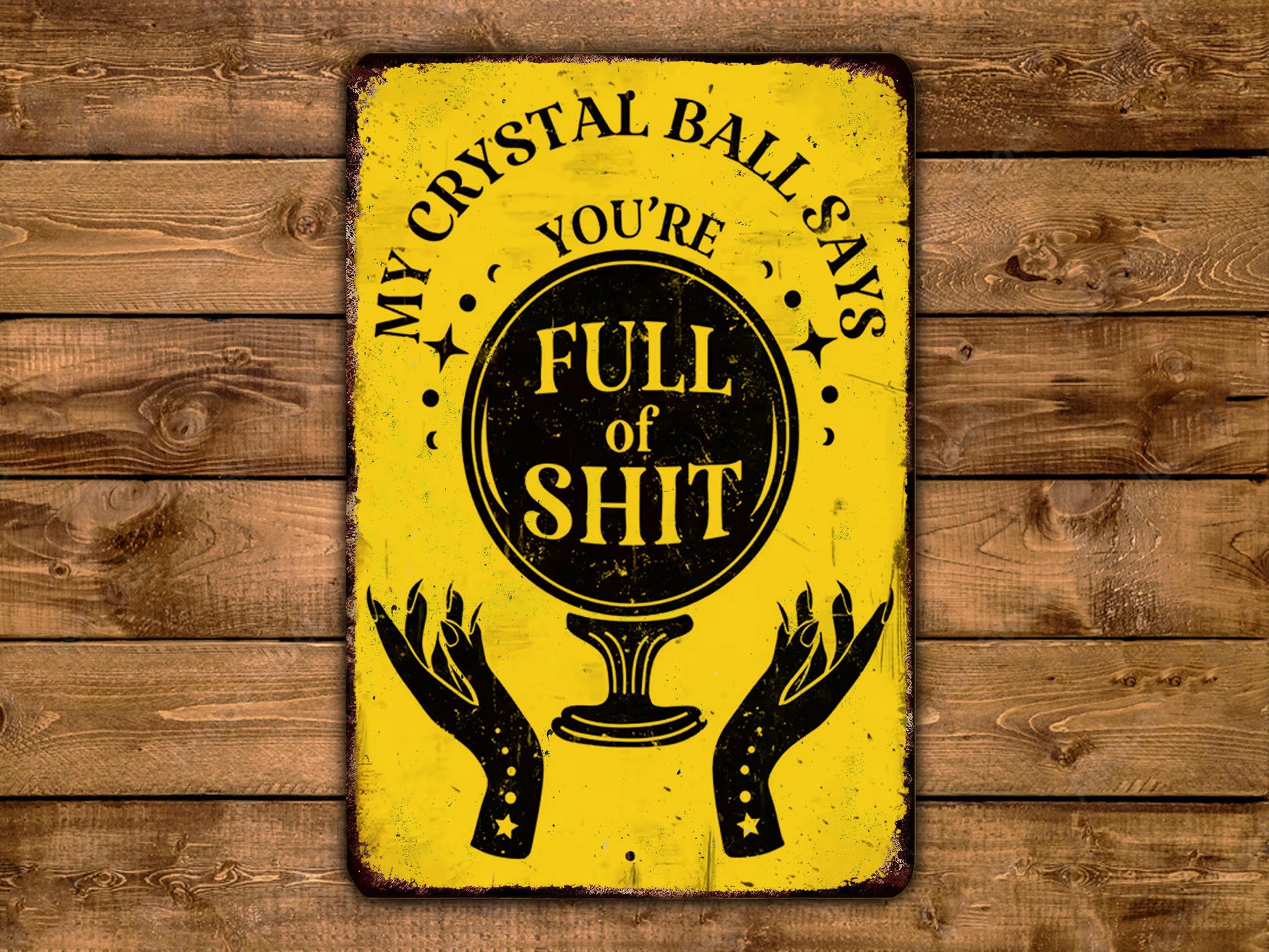 a yellow sign with a black and white design, displaying the text "MY CRYSTAL BALL SAYS FULL OF SHIT" along with a crystal ball illustration.