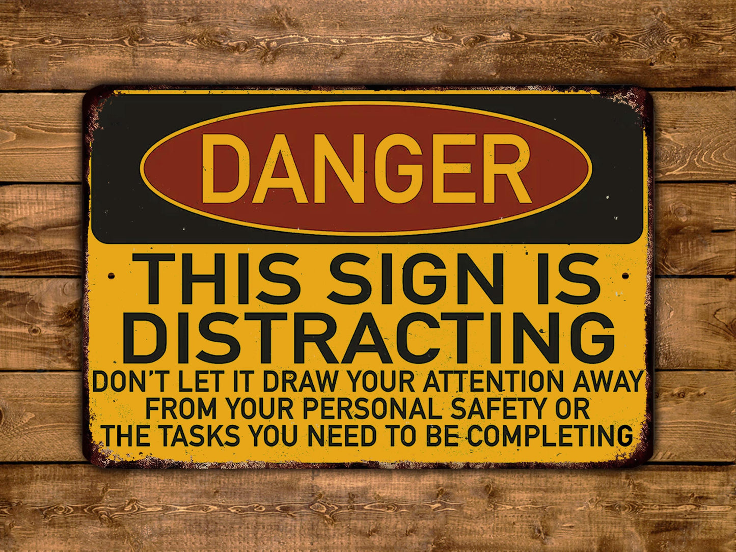 The image is a warning sign with the word "DANGER" in bold letters, indicating a potential hazard or danger. The sign also contains a cautionary message that says "THIS SIGN IS DISTRACTING" and advises not to draw attention away from personal safety or the tasks that need to be completed.
