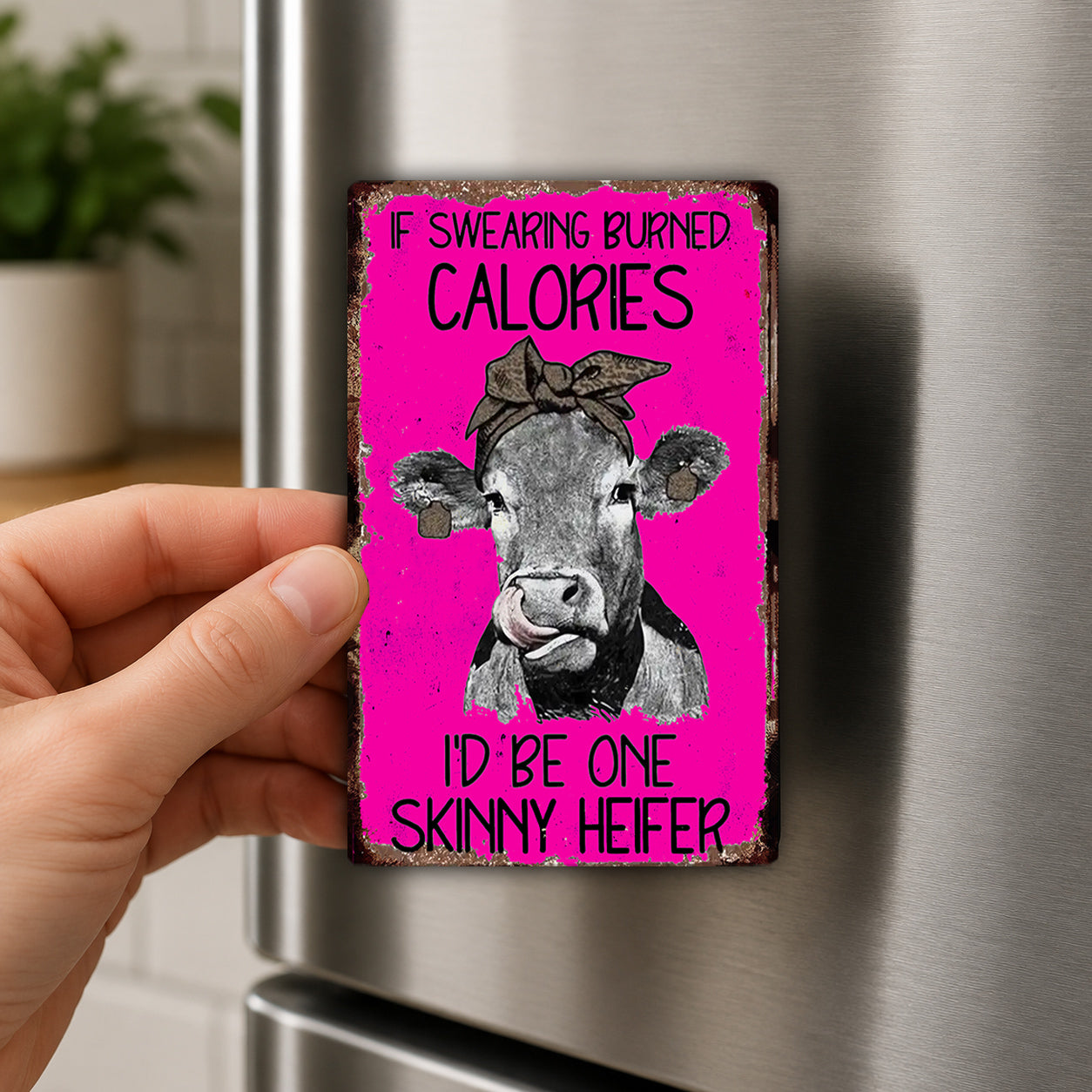 a person holding a pink sign with a cow on it.