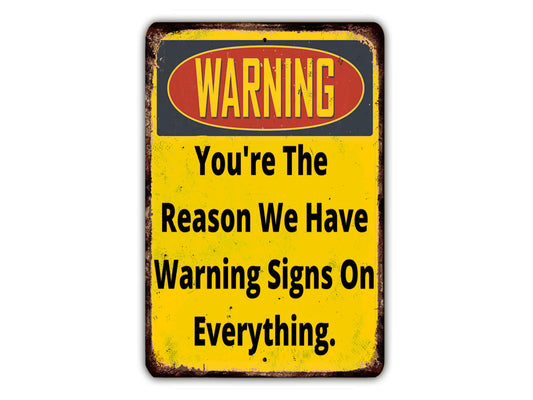 a yellow warning sign with the words warning you're the reason we have warning