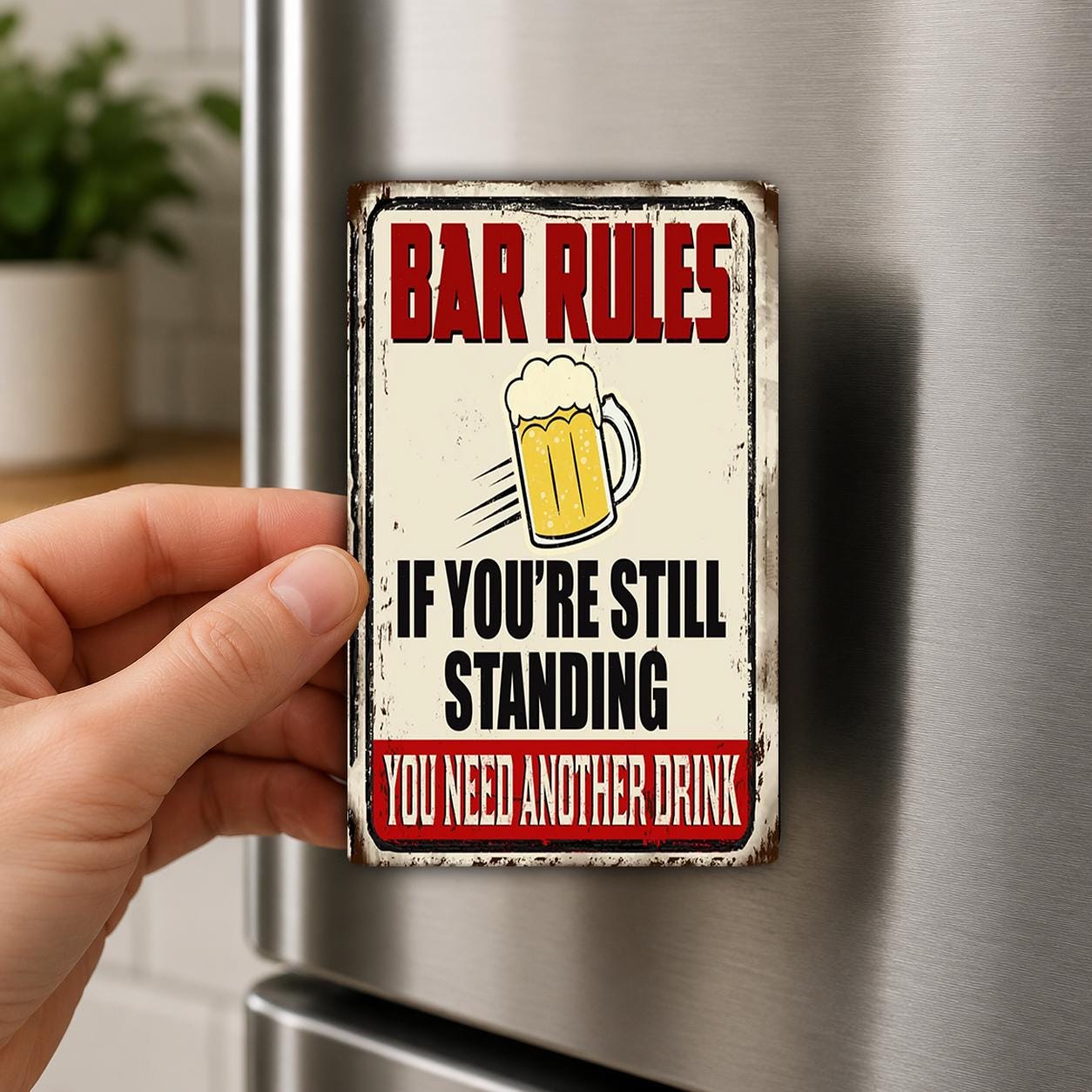 A person's hand is holding a metal sign with the text "BAR RULES IF YOU'RE STILL STANDING YOU NEED ANOTHER DRINK" on it.