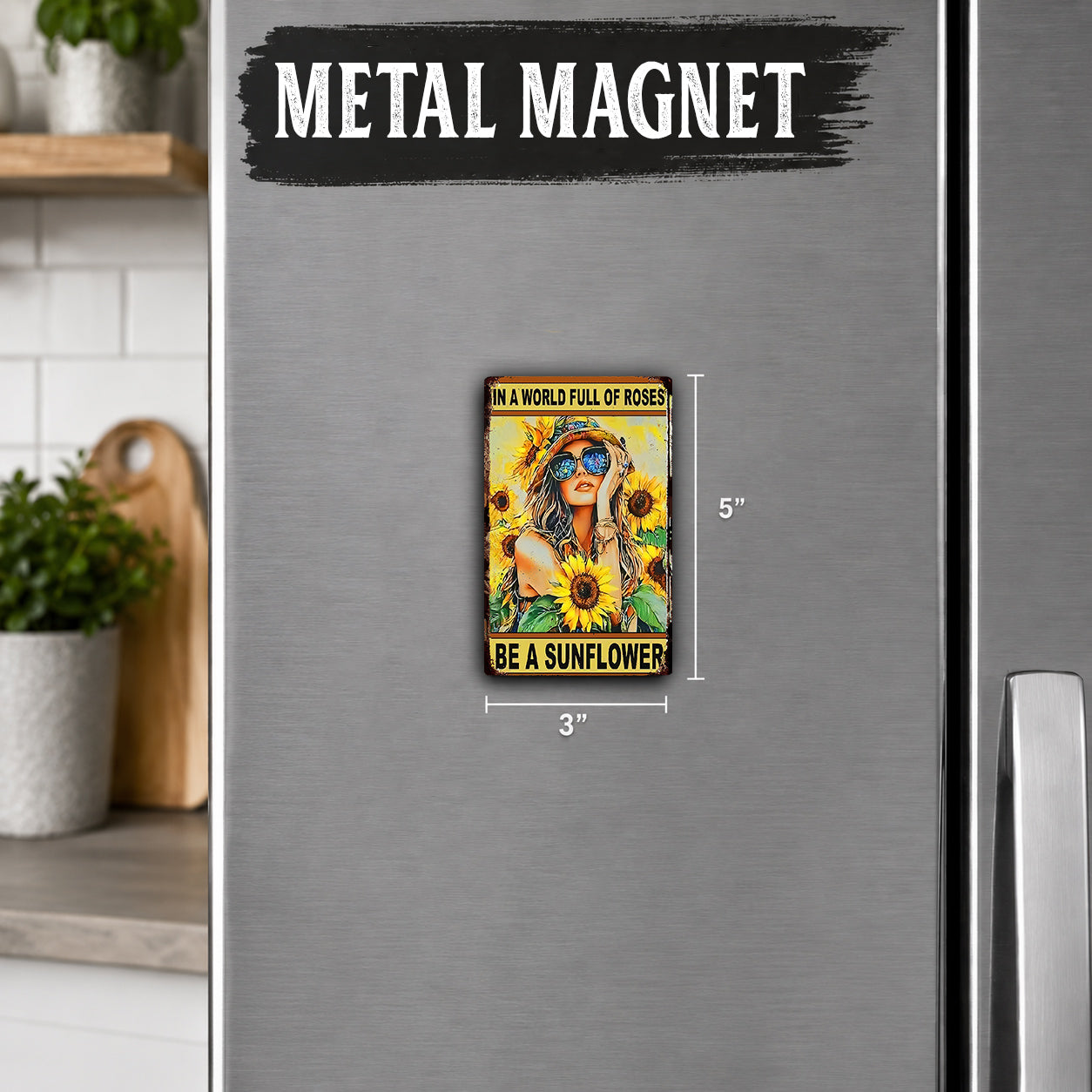 a small, colorful magnet with a woman wearing a sunflower and the text "Be a sunflower" on it. The magnet is placed on a refrigerator, and there is a wooden cutting board and a potted plant visible in the background.